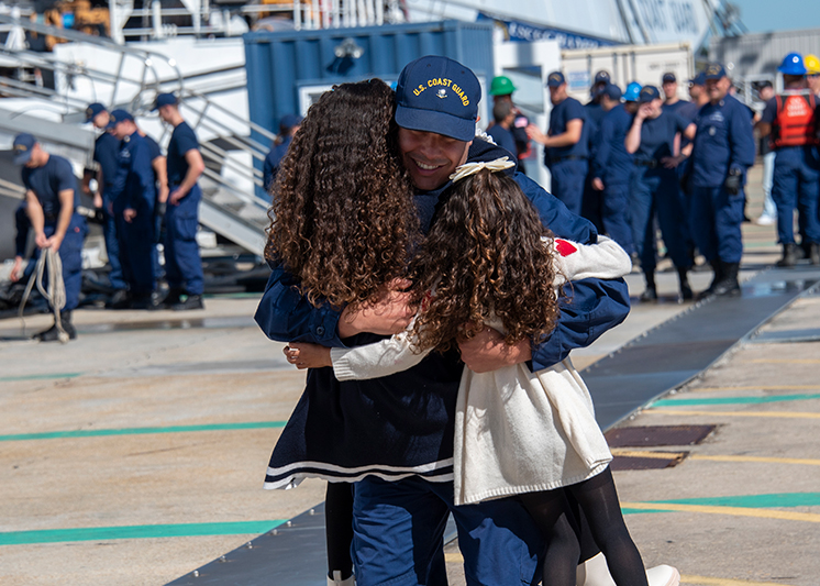 A man hugging his daughters. Links to Gifts of Life Insurance